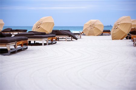 Empty beds with beach umbrellas on the beach Stock Photo - Premium Royalty-Free, Code: 625-01039820