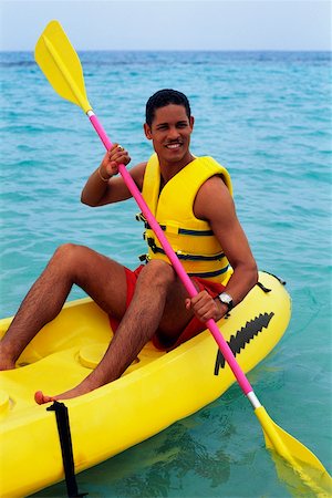 A man is boating in an inflatable kayak, Discovery Bay, Jamaica Stock Photo - Premium Royalty-Free, Code: 625-01040815