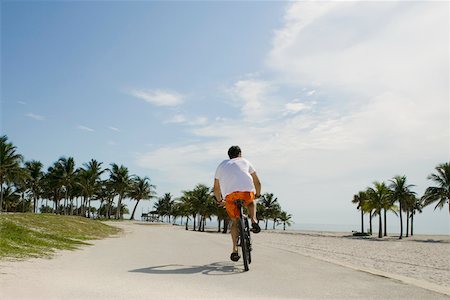 simsearch:625-01095436,k - Rear view of a young man cycling on the road Stock Photo - Premium Royalty-Free, Code: 625-01094058