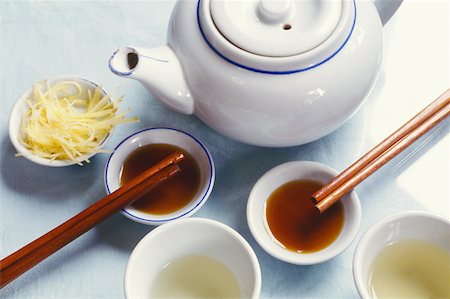 High angle view of a teapot with tea in bowls and chopsticks Stock Photo - Premium Royalty-Free, Code: 625-01094313