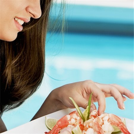 people eating seafood - Close-up of a young woman eating shrimp Stock Photo - Premium Royalty-Free, Code: 625-01095376