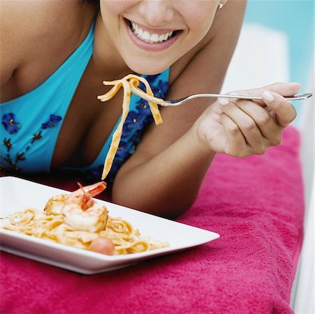 simsearch:625-01748850,k - Close-up of a young woman eating pasta with a fork Foto de stock - Sin royalties Premium, Código: 625-01095380