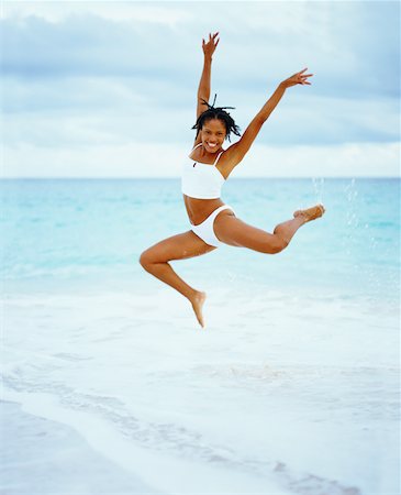 Low angle view of a young woman jumping on the beach, Bermuda Stock Photo - Premium Royalty-Free, Code: 625-01095875