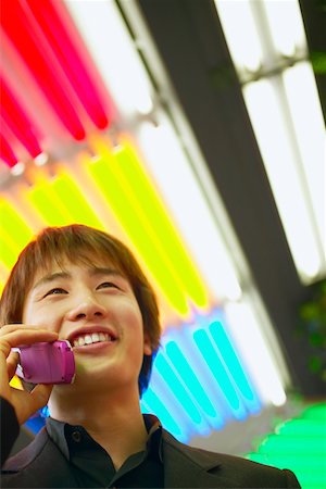 simsearch:625-01265118,k - Low angle view of a young man talking on a mobile phone Fotografie stock - Premium Royalty-Free, Codice: 625-01096010