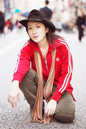 red scarf woman - Portrait of a young woman squatting on the street Stock Photo - Premium Royalty-Free, Code: 625-01096050