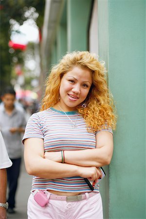 simsearch:625-01097695,k - Portrait of a young woman leaning against a wall and smiling Foto de stock - Royalty Free Premium, Número: 625-01096961