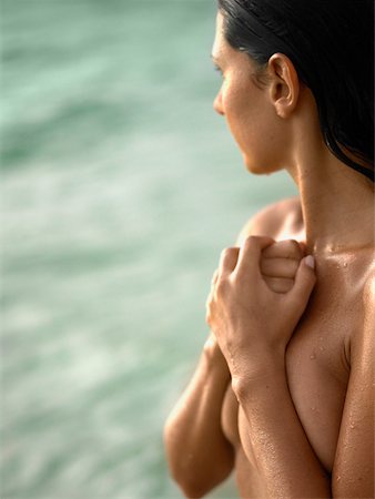 Close-up of a young woman covering her breast with her hand Stock Photo - Premium Royalty-Free, Code: 625-01097080