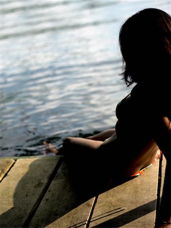 silhouette people sitting on a dock - Side profile of a young woman sitting on a pier Foto de stock - Sin royalties Premium, Código: 625-01097107