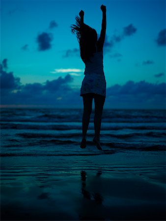 Silhouette of a teenage girl jumping on the beach at dusk Stock Photo - Premium Royalty-Free, Code: 625-01097118