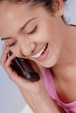 simsearch:630-01078178,k - Portrait d'une jeune femme parlant sur un téléphone mobile et souriant Photographie de stock - Premium Libres de Droits, Code: 625-01097333