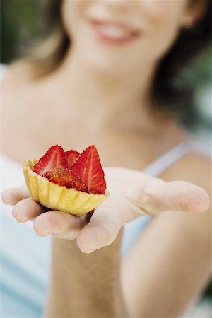 simsearch:625-01748850,k - Close-up of a young woman holding a strawberry tart and smiling Foto de stock - Sin royalties Premium, Código: 625-01097522