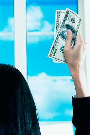 Rear view of a businesswoman holding dollar bills Fotografie stock - Premium Royalty-Free, Codice: 625-01097535
