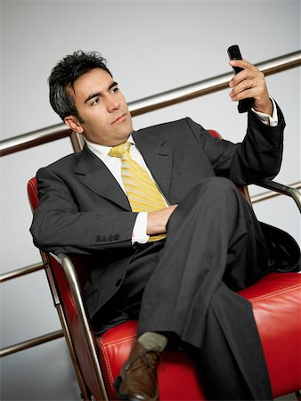 simsearch:625-02266709,k - Close-up of a businessman sitting and looking at a mobile phone Foto de stock - Sin royalties Premium, Código: 625-01097586