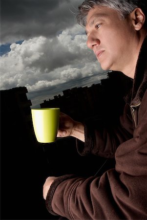 Profil de côté d'un homme senior tenant une tasse de café et de la pensée Photographie de stock - Premium Libres de Droits, Code: 625-01097645