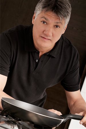 simsearch:625-02267785,k - Portrait of a senior man holding a frying pan in the kitchen Foto de stock - Royalty Free Premium, Número: 625-01097660