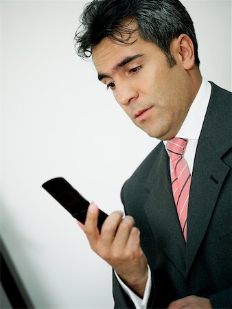 simsearch:625-02266709,k - Close-up of a businessman looking at a mobile phone Foto de stock - Sin royalties Premium, Código: 625-01097690