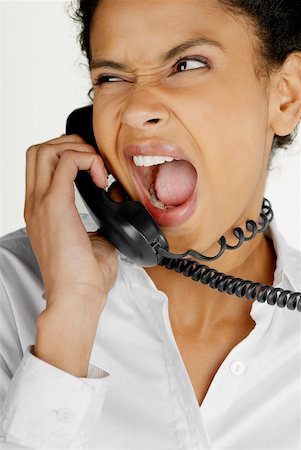 phone young woman upset - Close-up of a businesswoman talking on telephone and making a face Stock Photo - Premium Royalty-Free, Code: 625-01097785