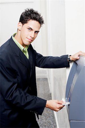 Portrait of a businessman inserting a credit card into an ATM Foto de stock - Sin royalties Premium, Código: 625-01097962