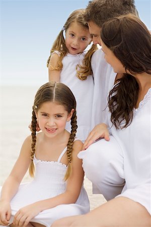 simsearch:625-01748789,k - Close-up of a young couple and their two daughters sitting on the beach Foto de stock - Royalty Free Premium, Número: 625-01098002
