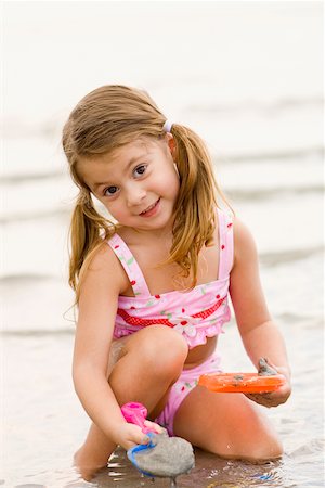 Portrait of a girl playing with toys on the beach Stock Photo - Premium Royalty-Free, Code: 625-01098073