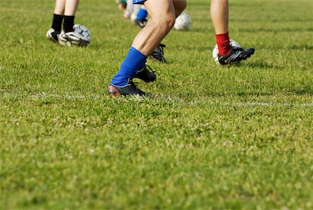 socks group - Low section view of soccer players playing soccer in a soccer field Stock Photo - Premium Royalty-Free, Code: 625-01091885