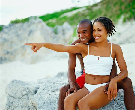 dreadlocks on african americans - Close-up of a young couple sitting on a rock and smiling, Bermuda Foto de stock - Sin royalties Premium, Código: 625-01092097