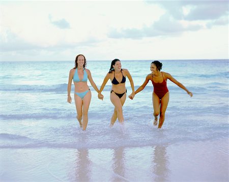 picture of white and black people holding hands - Three young women walking and holding hands on the beach, Bermuda Stock Photo - Premium Royalty-Free, Code: 625-01092093