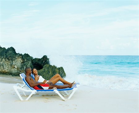 Side profile of a young couple lying on lounge chairs on the beach, Bermuda Stock Photo - Premium Royalty-Free, Code: 625-01092139