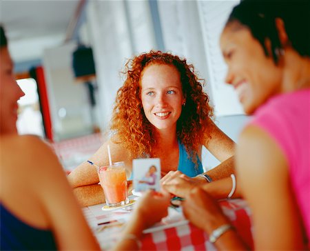 Three young women sitting around a table, Bermuda Stock Photo - Premium Royalty-Free, Code: 625-01092144