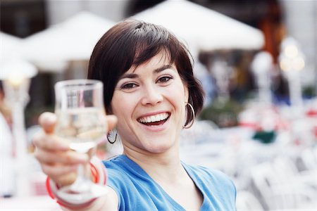 simsearch:625-02267871,k - Portrait of a young woman holding up a glass of white wine Stock Photo - Premium Royalty-Free, Code: 625-01092572