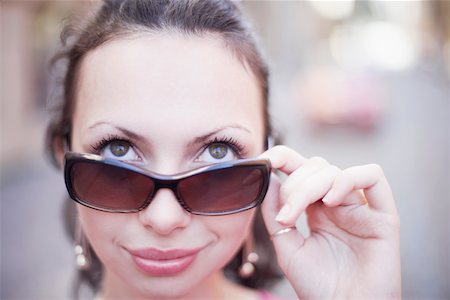 peeping fashion - Gros plan d'une jeune femme tenant des lunettes de soleil Photographie de stock - Premium Libres de Droits, Code: 625-01092596