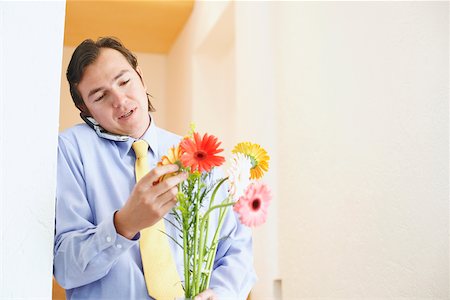 simsearch:625-02266709,k - Close-up of a businessman talking on a mobile phone and holding a bunch of flowers Foto de stock - Sin royalties Premium, Código: 625-01092803