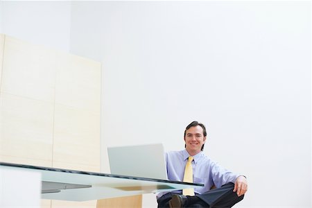 simsearch:625-01096675,k - Portrait of a businessman sitting in an office with a laptop in front of him Stock Photo - Premium Royalty-Free, Code: 625-01092812