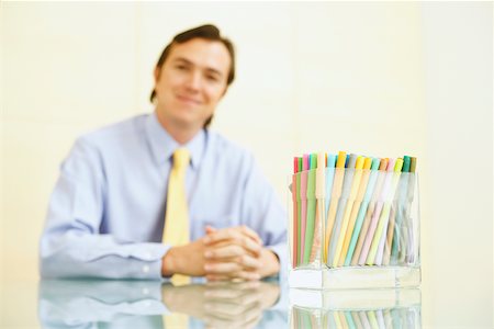 simsearch:625-01096766,k - Portrait of a businessman sitting with felt tip pens in a pen stand in front of him Stock Photo - Premium Royalty-Free, Code: 625-01092837