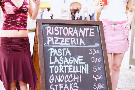 Mid section view of two women standing near a signboard Stock Photo - Premium Royalty-Free, Code: 625-01092855