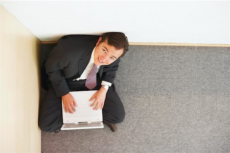 simsearch:625-01096675,k - High angle view of a businessman sitting on the floor and using a laptop Stock Photo - Premium Royalty-Free, Code: 625-01092905