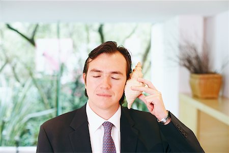 simsearch:625-01096766,k - Close-up of a businessman holding a shell close to his ear Stock Photo - Premium Royalty-Free, Code: 625-01093046