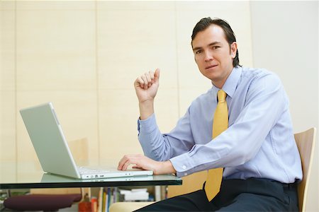 simsearch:625-01096766,k - Portrait of a businessman using a laptop in an office Stock Photo - Premium Royalty-Free, Code: 625-01093053