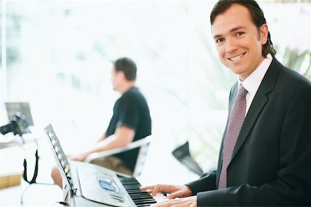 Portrait of a businessman playing the piano Stock Photo - Premium Royalty-Free, Code: 625-01093092