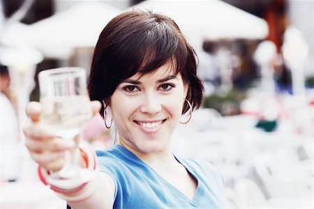 simsearch:625-02267871,k - Portrait of a young woman holding up a glass of white wine Stock Photo - Premium Royalty-Free, Code: 625-01093173