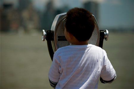 Rear view of a boy looking through coin-operated binoculars, Manhattan, New York City, New York State, USA Stock Photo - Premium Royalty-Free, Code: 625-01093299