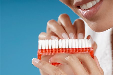 Close-up of a young woman cleaning her fingernails with a nail brush Foto de stock - Sin royalties Premium, Código: 625-01093416