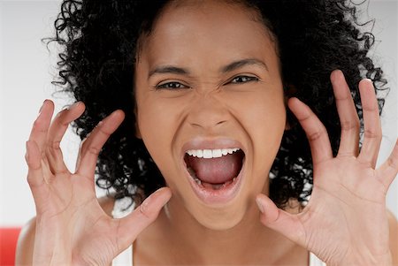 Portrait of a young woman shouting and gesturing with her hands Stock Photo - Premium Royalty-Free, Code: 625-01093433