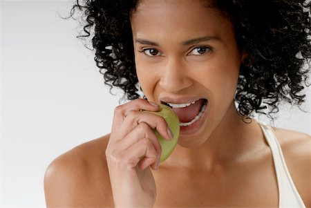 people with fruits cutout - Portrait of a young woman eating an apple Stock Photo - Premium Royalty-Free, Code: 625-01093442