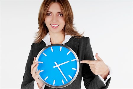 Portrait of a businesswoman pointing at a clock and smiling Stock Photo - Premium Royalty-Free, Code: 625-01093709