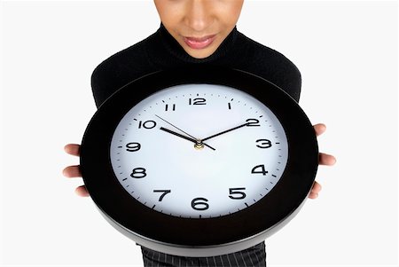 Close-up of a businesswoman holding a clock Stock Photo - Premium Royalty-Free, Code: 625-01093728