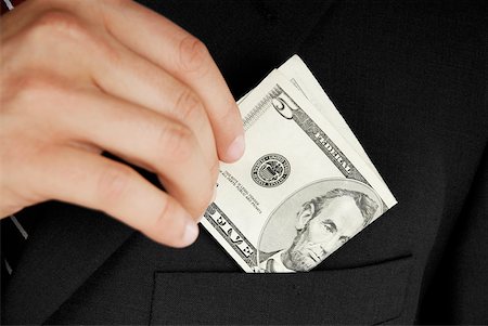 Mid section view of a businessman putting dollar bills in his pocket Foto de stock - Sin royalties Premium, Código: 625-01093730