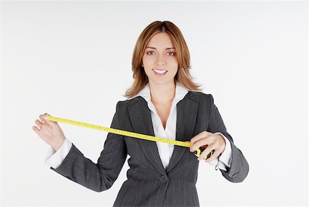simsearch:625-01093712,k - Portrait of a businesswoman holding a measuring tape and smiling Stock Photo - Premium Royalty-Free, Code: 625-01093732