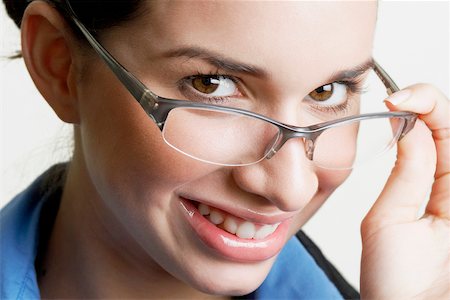 simsearch:625-01093712,k - Portrait of a businesswoman peeking over her eyeglasses and smiling Stock Photo - Premium Royalty-Free, Code: 625-01093740