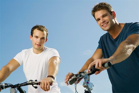 simsearch:625-01095436,k - Portrait of two young men smiling and holding bicycles Stock Photo - Premium Royalty-Free, Code: 625-01093884